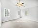 Bright bedroom featuring three windows, neutral carpet, and a ceiling fan at 3604 Tunas St, Raleigh, NC 27616