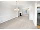 Bright dining room featuring neutral walls, carpet flooring, a chandelier, and ample natural light at 3604 Tunas St, Raleigh, NC 27616