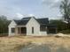 New home showing white brick, dark gray siding, black roof and wood porch posts at 395 Meadow Walk Dr, Fuquay Varina, NC 27526