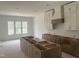 Bright kitchen area with white cabinets, a gray island, and large windows at 395 Meadow Walk Dr, Fuquay Varina, NC 27526