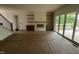 Spacious living room featuring floating shelves, modern fireplace, with view to a large covered deck at 395 Meadow Walk Dr, Fuquay Varina, NC 27526