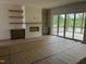 Living room features fireplace flanked by floating shelves, as well as sliding door access to back porch at 395 Meadow Walk Dr, Fuquay Varina, NC 27526