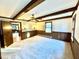 Spacious bedroom with carpet, wood beams, and paneled walls at 4100 Durham Rd, Raleigh, NC 27614