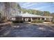 A sprawling ranch house with a metal roof and lush green bushes at 4100 Durham Rd, Raleigh, NC 27614