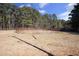 Expansive dirt horse arena with tall trees in the background at 4100 Durham Rd, Raleigh, NC 27614