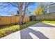 Large backyard with a wooden fence, a concrete patio, and mature trees, providing privacy and shade at 518 Worth St, Raleigh, NC 27601