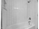 White tiled bathroom with a shower-tub combination, featuring clean lines and a minimalist design at 518 Worth St, Raleigh, NC 27601