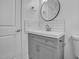 Modern bathroom featuring a gray vanity, round mirror, and subway tile backsplash for a sleek and stylish design at 518 Worth St, Raleigh, NC 27601