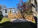 Charming blue house with a yellow door, a wooden deck, and lush greenery, creating a welcoming outdoor space at 518 Worth St, Raleigh, NC 27601