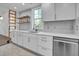 Stylish kitchen with white cabinetry, stainless steel dishwasher, and decorative open shelving at 518 Worth St, Raleigh, NC 27601