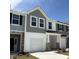 Charming townhouse exterior with gray siding, white trim, and a one-car garage on a sunny day at 6132 Arsenal Ave, Raleigh, NC 27610