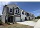 Street view of newly constructed townhouses featuring varying colors and attached one-car garages at 6132 Arsenal Ave, Raleigh, NC 27610