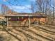 A brick home featuring a covered back deck, a grassy yard, and trees at 6423 Whitt Rd, Durham, NC 27712