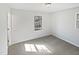 Bright bedroom with neutral carpet, white trim, and two windows allowing for natural light at 6423 Whitt Rd, Durham, NC 27712