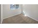 A simple bedroom features neutral carpet, white walls, and a window at 6423 Whitt Rd, Durham, NC 27712