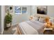 This staged bedroom features neutral tones, light wood furnishings and decor, and a large window at 6423 Whitt Rd, Durham, NC 27712