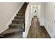 Carpeted staircase with white wood trim and handrail, leading to the upper floor at 7104 Proctor Hill Dr, Raleigh, NC 27613