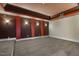 Finished basement space with unique wall sconces, red pillars and carpeting, perfect for entertainment at 1013 Timber Mist Ct, Cary, NC 27519