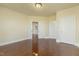 Spacious bedroom with hardwood floors has neutral walls and trim with an open door to the stairs at 1013 Timber Mist Ct, Cary, NC 27519