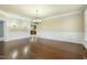 Spacious dining room with beautiful hardwood floors, chandelier and classic wainscoting at 1013 Timber Mist Ct, Cary, NC 27519