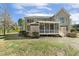 Rear exterior showcasing a brick facade and a screened-in porch for outdoor relaxation at 1013 Timber Mist Ct, Cary, NC 27519