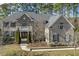 A beautiful exterior elevation view of a brick and stone home with a well-manicured lawn and mature trees at 1013 Timber Mist Ct, Cary, NC 27519