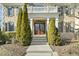 View of home's front entrance, featuring double doors, stone steps, and lush landscaping at 1013 Timber Mist Ct, Cary, NC 27519