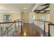 Elegant hallway with hardwood floors, white railing, and coffered ceiling detail at 1013 Timber Mist Ct, Cary, NC 27519