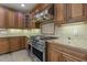 Chef's kitchen boasts a high-end stainless steel range and hood, custom cabinetry and tile backsplash at 1013 Timber Mist Ct, Cary, NC 27519