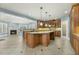 Spacious kitchen with large island, wooden cabinets, and stainless steel appliances open to living room fireplace at 1013 Timber Mist Ct, Cary, NC 27519