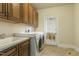 Well-equipped laundry area with sink, cabinets, and washer/dryer at 1013 Timber Mist Ct, Cary, NC 27519