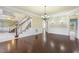Well-lit living room with a view of the staircase, hardwood floors and wainscoting at 1013 Timber Mist Ct, Cary, NC 27519