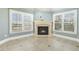 Cozy living room with tiled floors, fireplace and windows with a view of the surrounding landscape at 1013 Timber Mist Ct, Cary, NC 27519