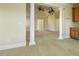Spacious living room featuring carpet, supporting columns, ceiling fan, and wet bar at 1013 Timber Mist Ct, Cary, NC 27519