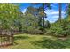 Lush backyard featuring mature trees, a well maintained lawn, and partial home view at 1031 Wait Ave, Wake Forest, NC 27587