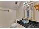 Bathroom features a modern glass vessel sink, black counter and gold mirror at 1031 Wait Ave, Wake Forest, NC 27587