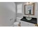 This half-bathroom features a glass vessel sink, dark countertop, and white cabinets at 1031 Wait Ave, Wake Forest, NC 27587