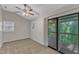 A bright bedroom features a fan, carpet, and sliding glass doors to the deck at 1031 Wait Ave, Wake Forest, NC 27587