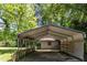 Shot of a covered carport connected to the house, surrounded by mature trees at 1031 Wait Ave, Wake Forest, NC 27587