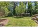 Exterior view of the home surrounded by a lush lawn, trees, and a covered carport at 1031 Wait Ave, Wake Forest, NC 27587