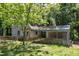 Side view of the home, featuring a covered carport and fence and mature trees at 1031 Wait Ave, Wake Forest, NC 27587