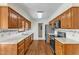 Well-lit kitchen with wood cabinets, granite countertops, and stainless steel appliances at 1031 Wait Ave, Wake Forest, NC 27587