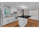 Updated kitchen boasts white cabinetry, stainless steel appliances, granite counters, and a breakfast bar at 1031 Wait Ave, Wake Forest, NC 27587