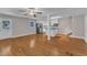 Open-concept living area flows into the kitchen, showcasing hardwood floors and a stainless steel refrigerator at 1031 Wait Ave, Wake Forest, NC 27587