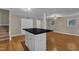 Open living space showing the hardwood floors and a kitchen island with black countertops at 1031 Wait Ave, Wake Forest, NC 27587