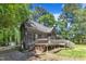 Back exterior of home with wood siding, back deck, and mature trees at 1031 Wait Ave, Wake Forest, NC 27587