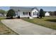 View of the home showing a long concrete driveway, well-manicured lawn and mature landscaping at 104 Eddy Ct, Benson, NC 27504