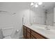 Bathroom featuring a double sink vanity with matching mirror and a standard toilet, well-lit with modern fixtures at 11425 Shadow Elms Ln, Raleigh, NC 27614