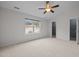 Large bedroom with neutral walls, carpet, ceiling fan, and bright window overlooking the neighborhood at 11425 Shadow Elms Ln, Raleigh, NC 27614