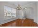 Light-filled dining room boasting hardwood floors, wainscoting, and stylish chandelier at 11425 Shadow Elms Ln, Raleigh, NC 27614